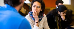 A student listens intently to a professor in a one-on-one conversation.