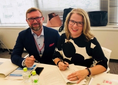 Alexandre Ponomarev and Maureen Sweeney signing their contracts to serve as chief and deputy chief interpreters at the 2020 Olympics.