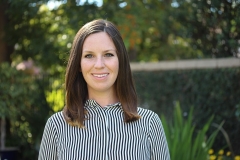 Ms. Erin Lannon smiling brightly with intelligent eyes looking professional in a black and white stripped shirt