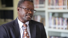 Edgard Coly sitting in chair in library