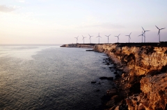 Photo of windmills along a shoreline.