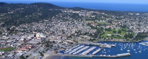 An aerial view of the Monterey Bay including boat harbor, city and hills, with view to the Pacific Ocean beyond