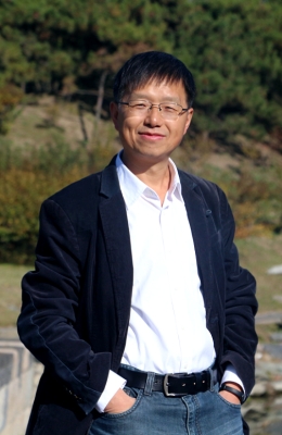 Hu Yong standing outside in front of trees