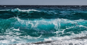 ocean waves of various colors of blue and turquiose, crashing gently