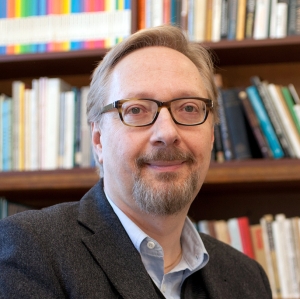 Prof. Petro in front of book shelf.