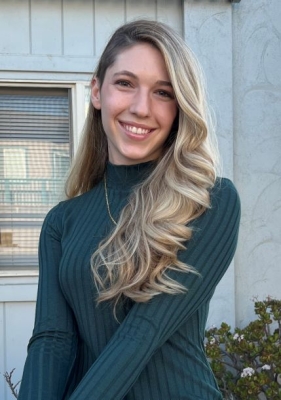 headshot of female, blonde hair, green sweater, smiling