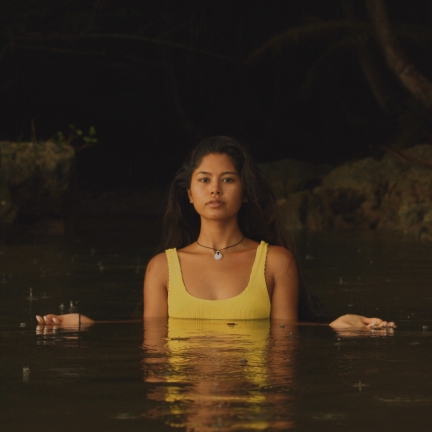 Franceska De Oro emerging from a dark pool of water in her native Guam