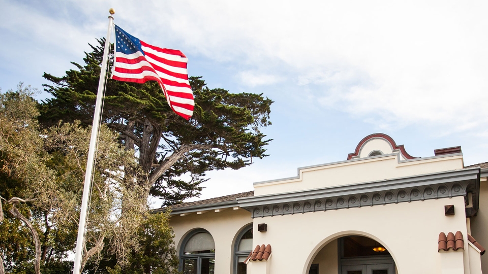An American flag flies outside the Segal Building, at the center of campus.