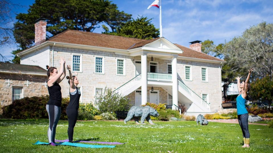 Students participate in a yoga class outside on campus.