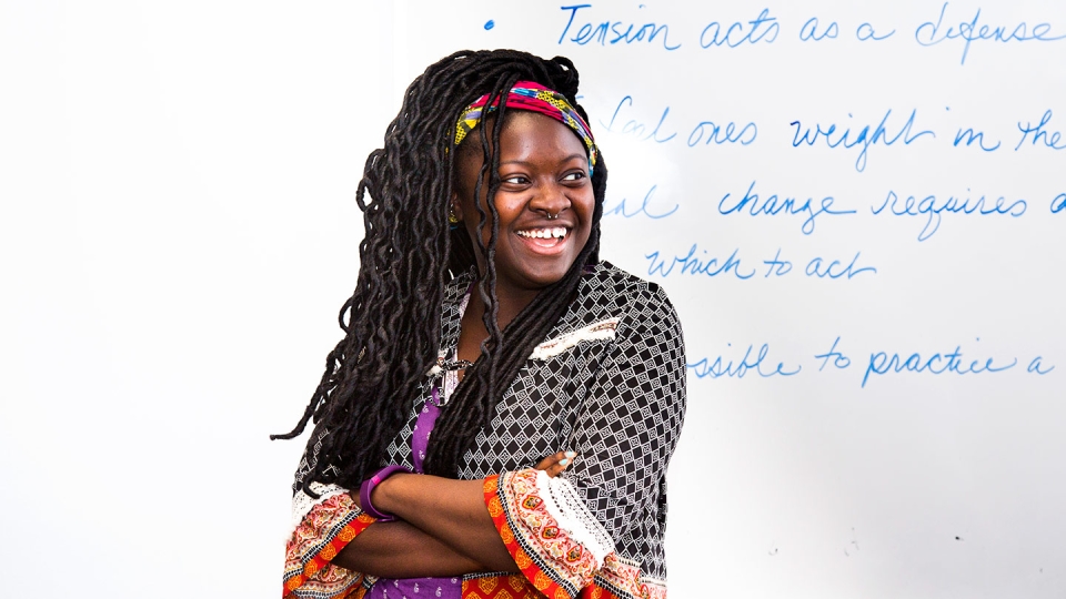 A smiling student makes a presentation in class.