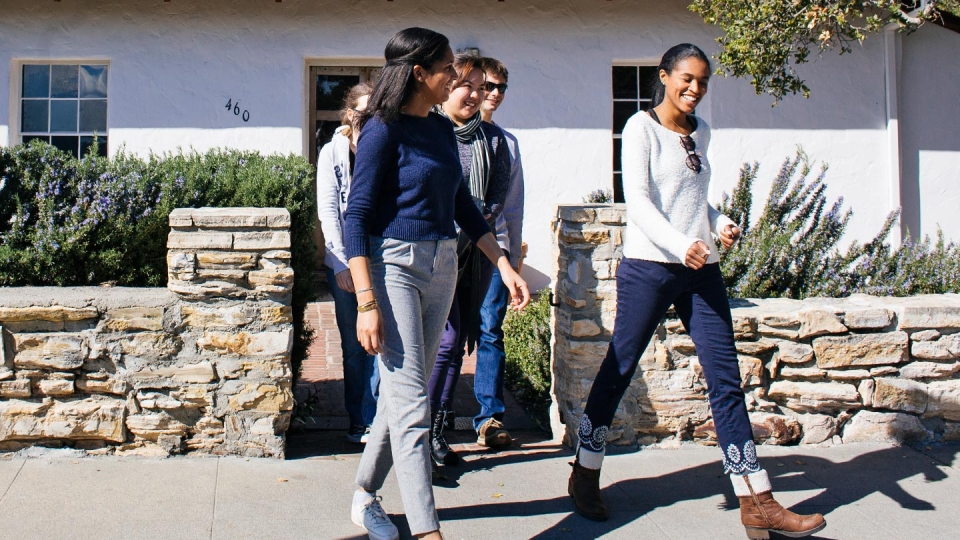 Five students walking together on campus.