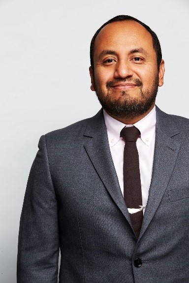Mr. Alvaro Sanchez wearing a suit and tie and smiling