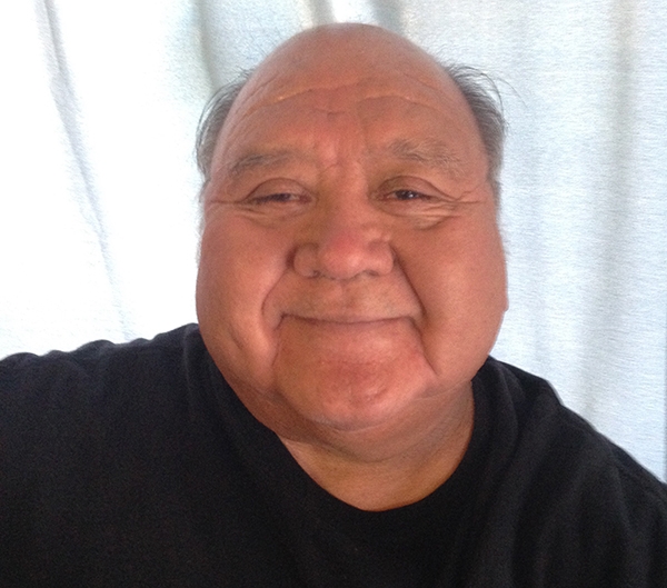 The Honorable Ron Goode, Tribal Chairman of the North Fork Mono Tribe, smiling with a grin and smiling eyes,in a black t-shirt