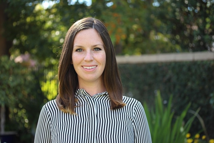 Ms. Erin Lannon smiling brightly with intelligent eyes looking professional in a black and white stripped shirt