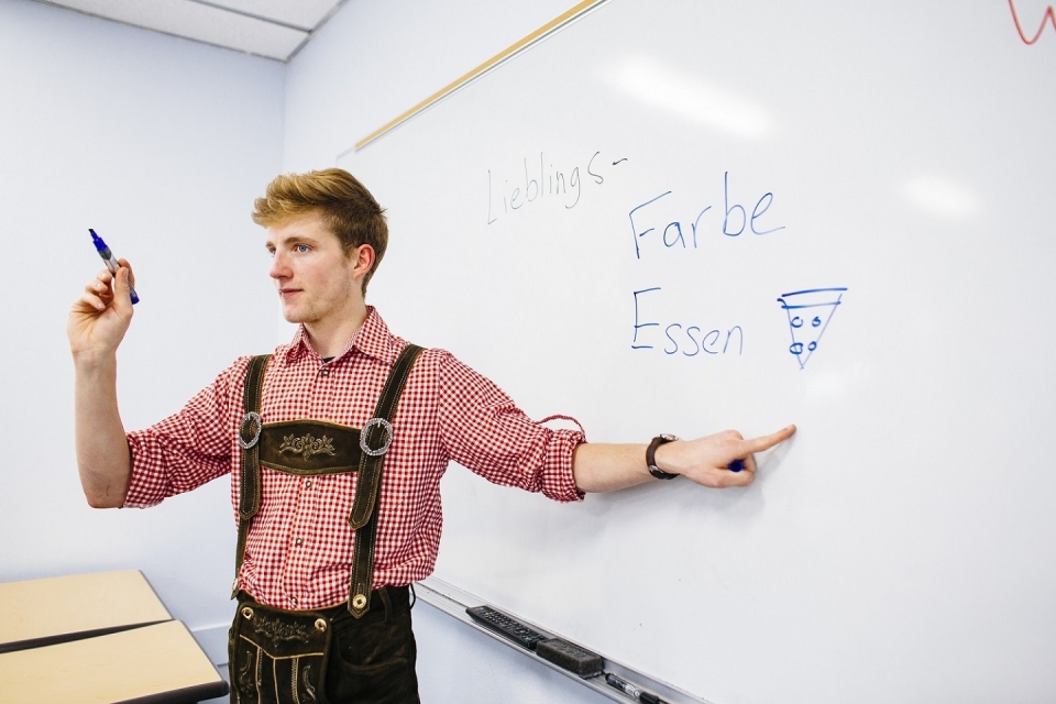 Student at white board teaching German