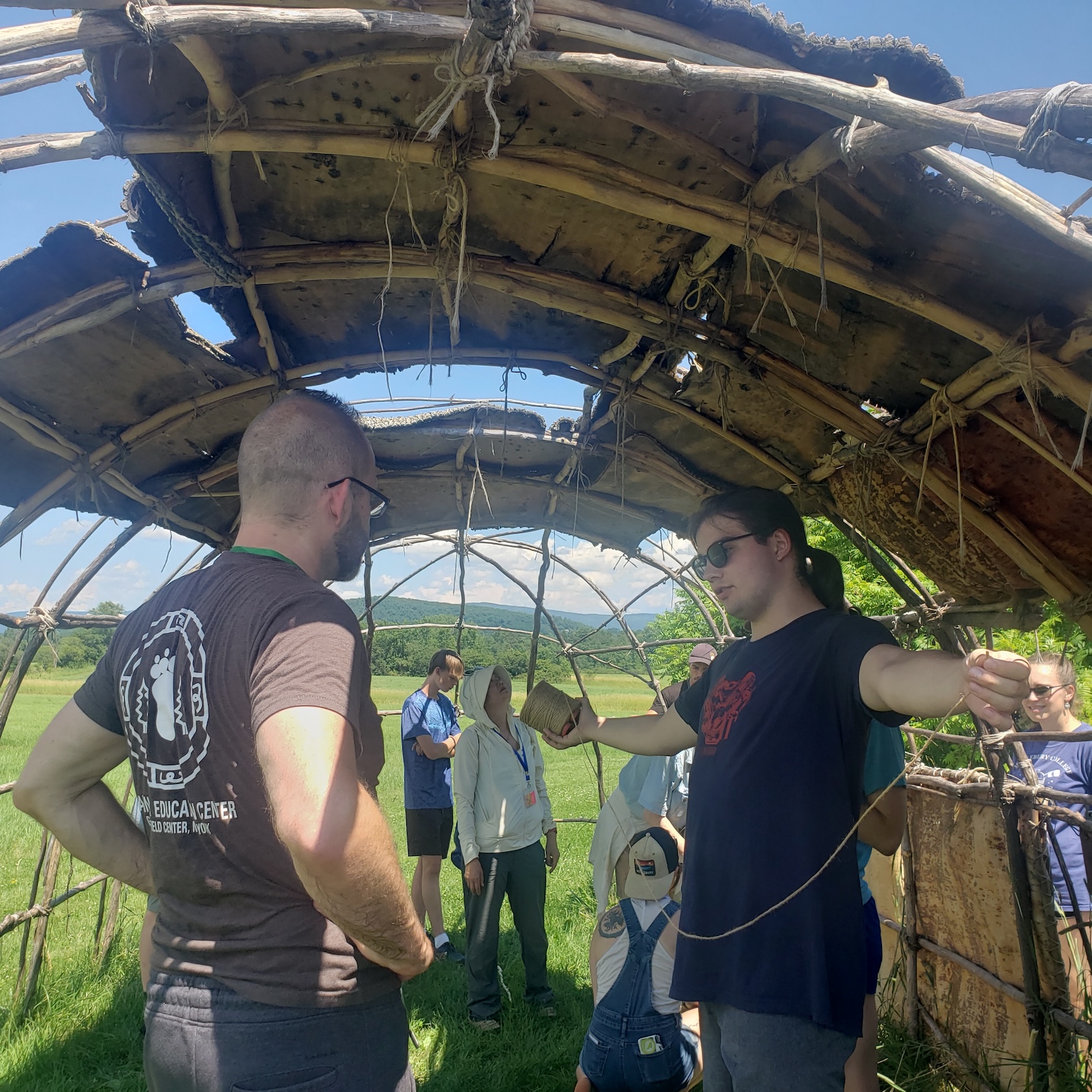 Students build a wooden structure outside. 