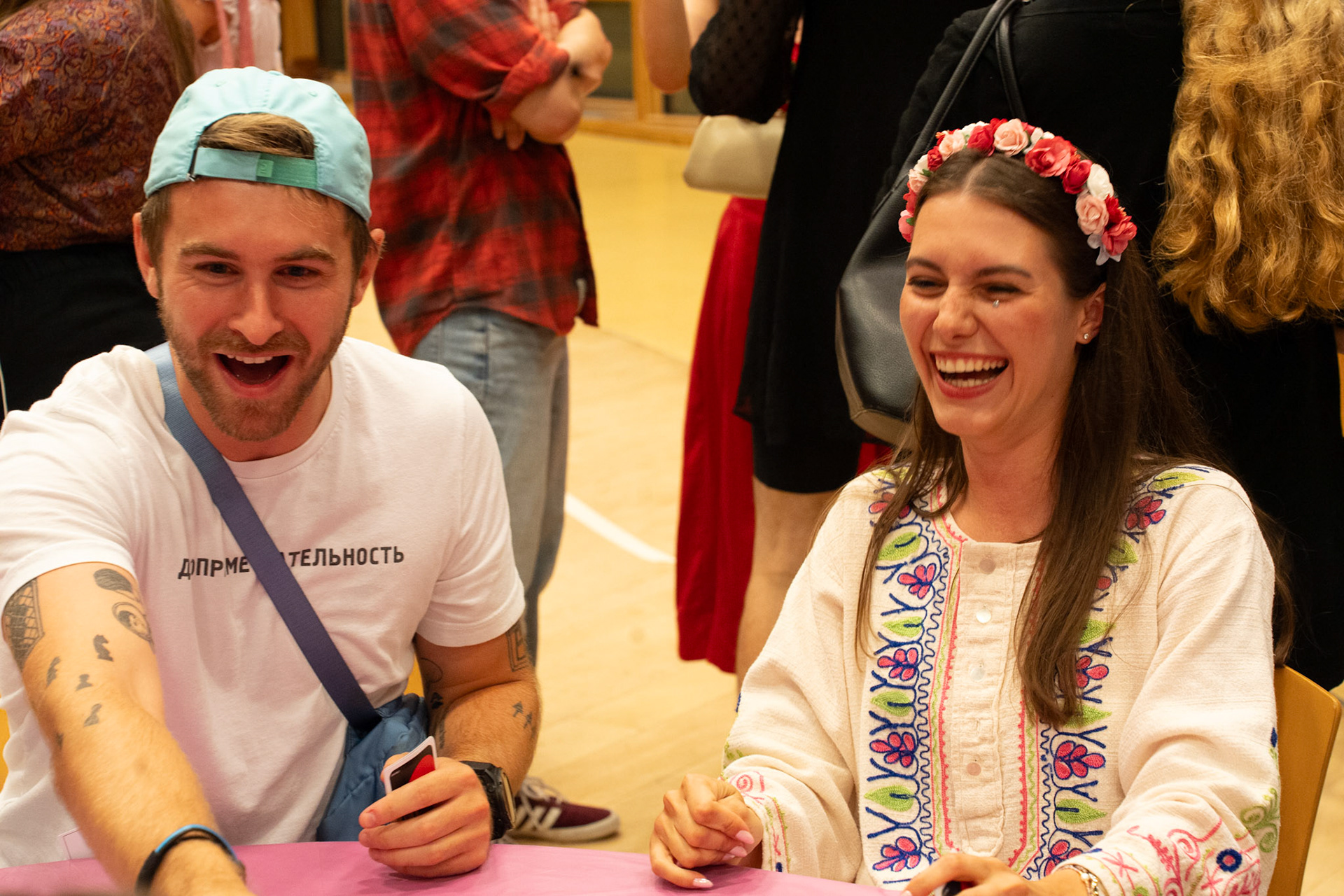 students smile as they play a card game. 