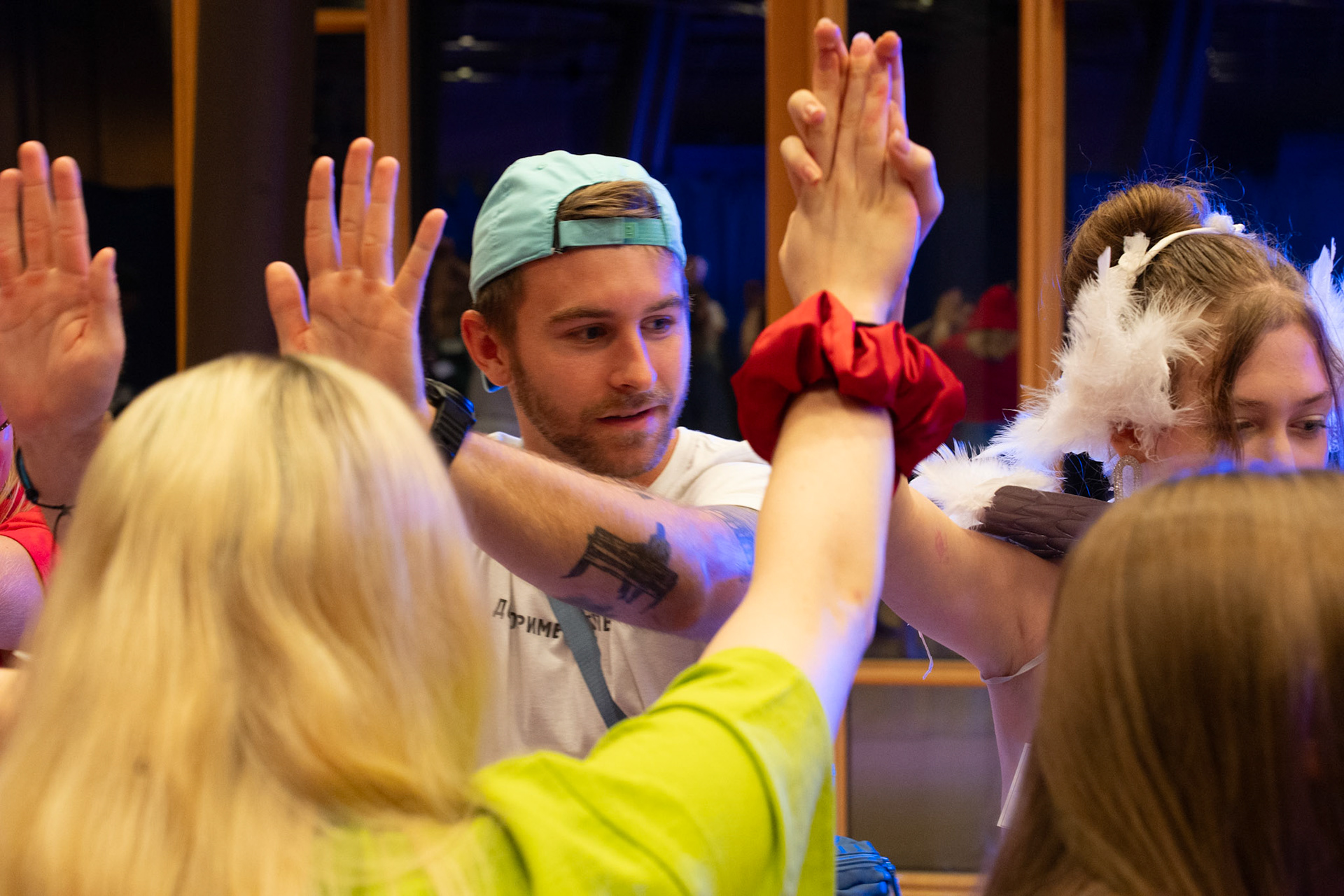 students join hands as they dance. 