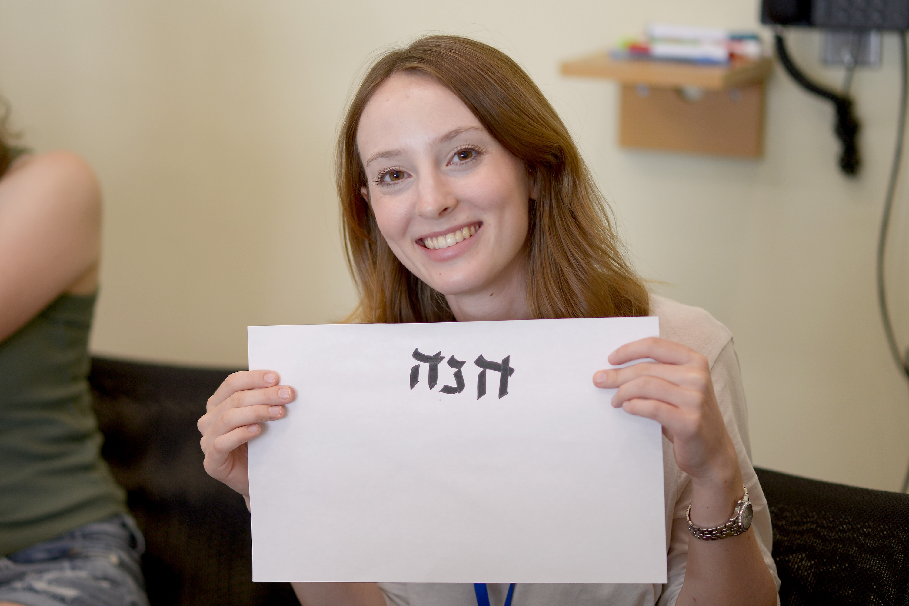 A student holds up her calligraphy. 