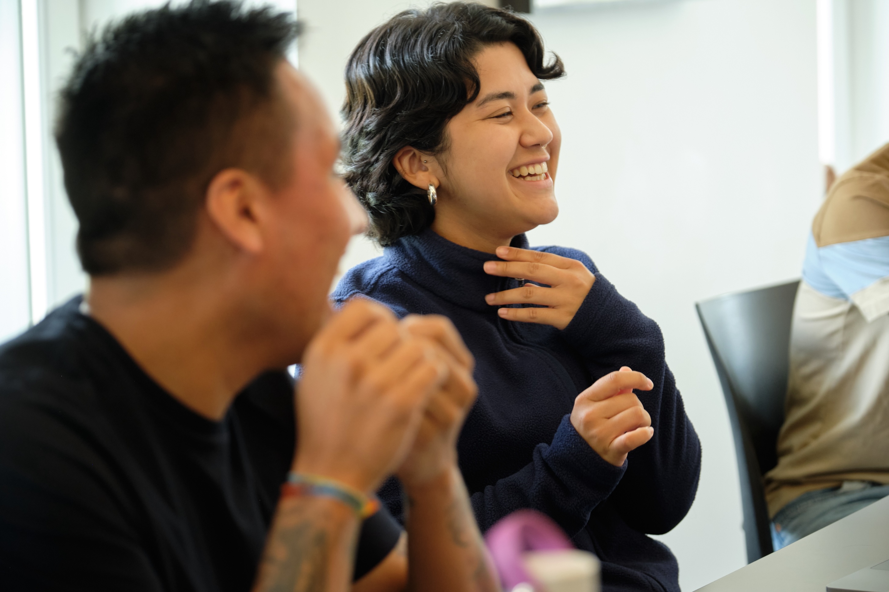 A woman and a man laugh in class. 