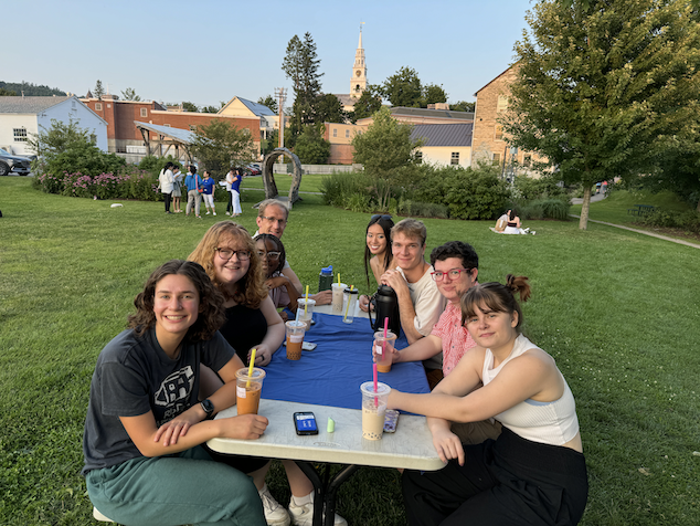 Chinese School students drink bubble tea together outside at a table. 