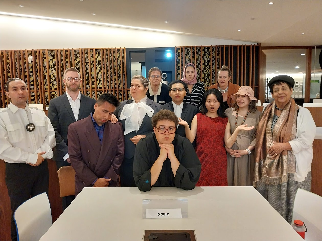 A group of students dressed up for a play at a white table. 