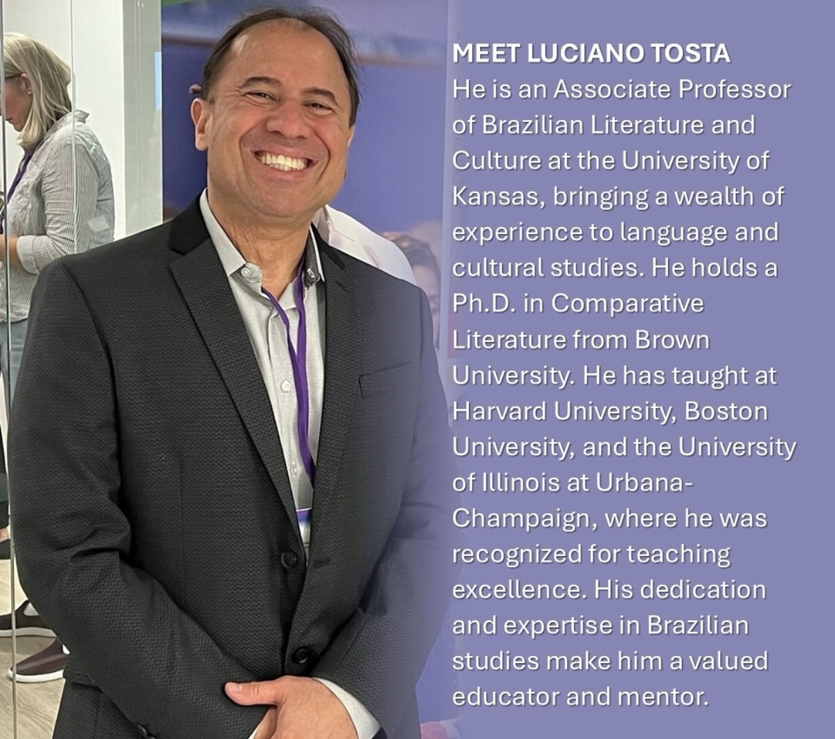 A man in a suit smiles at the camera 