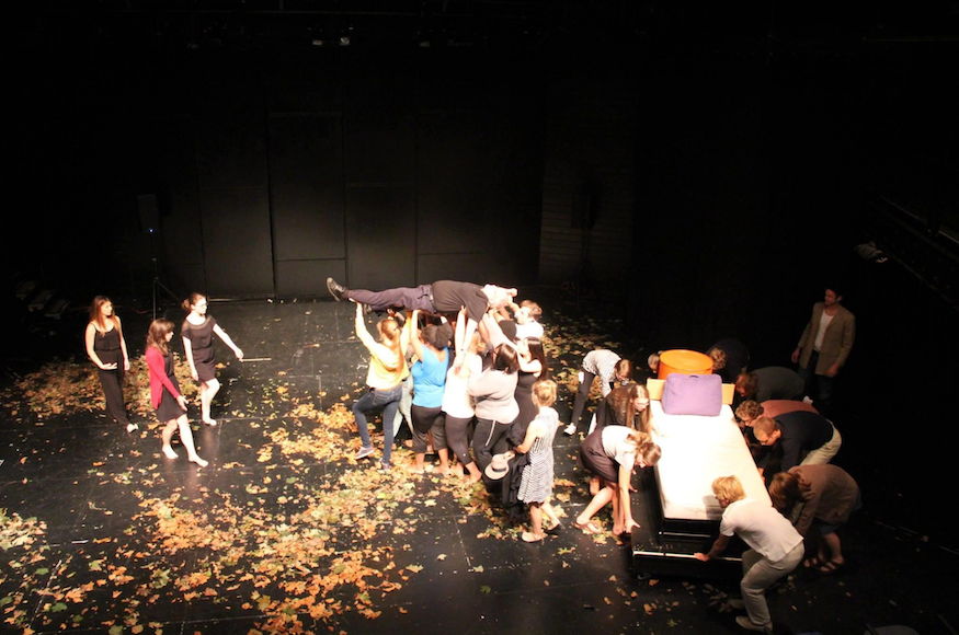 A man is carried across the stage in a School of French play at Middlebury.