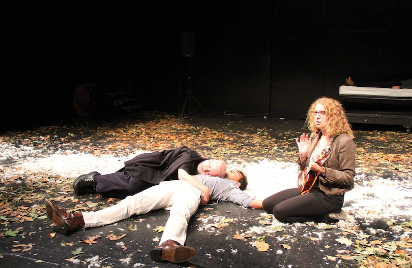 A man lays dying on stage at the School of French play. 