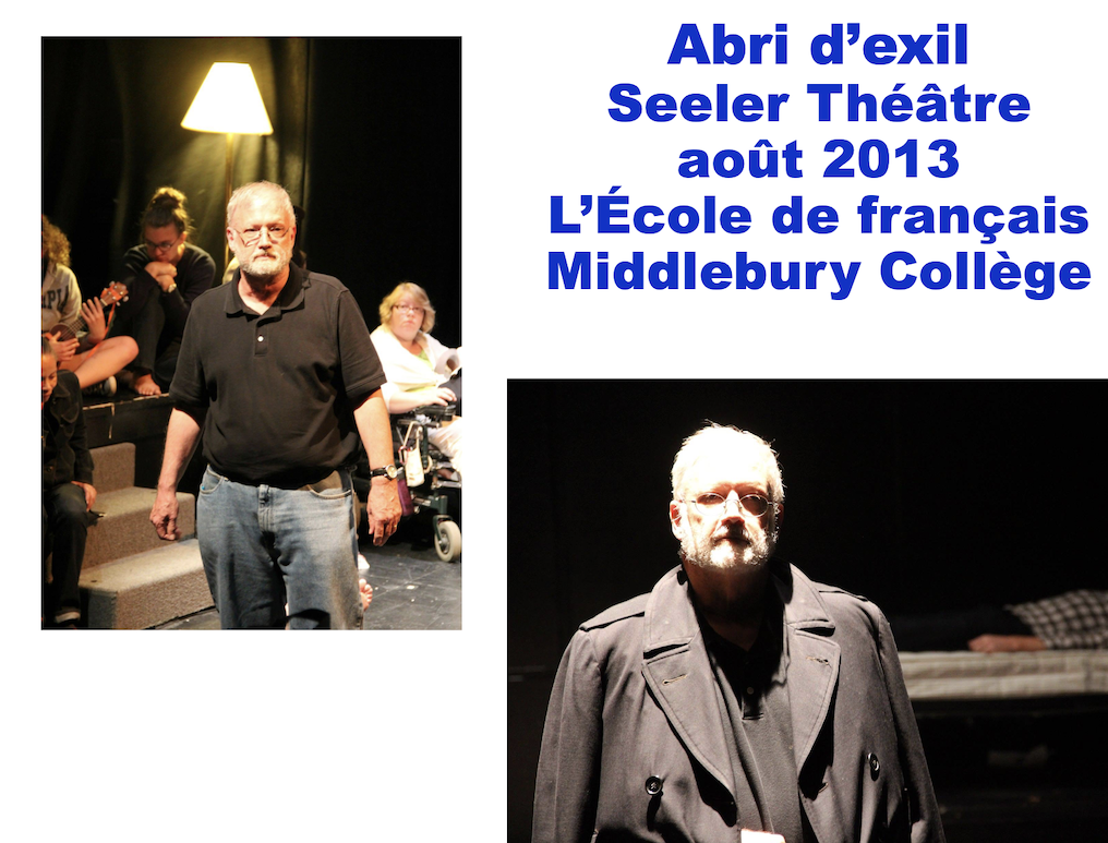 A man in a jacket stands on a stage with lights behind him. 