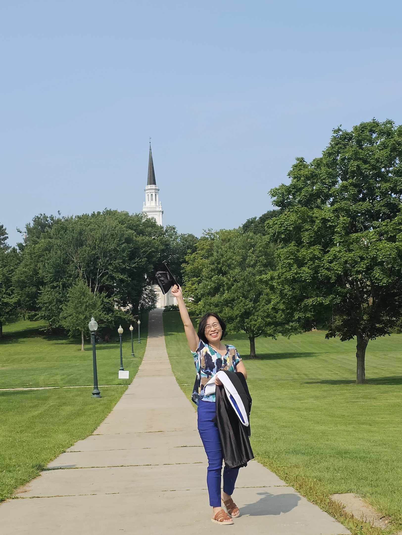 A woman pumps her fist in the air on the Middlebury College campus.