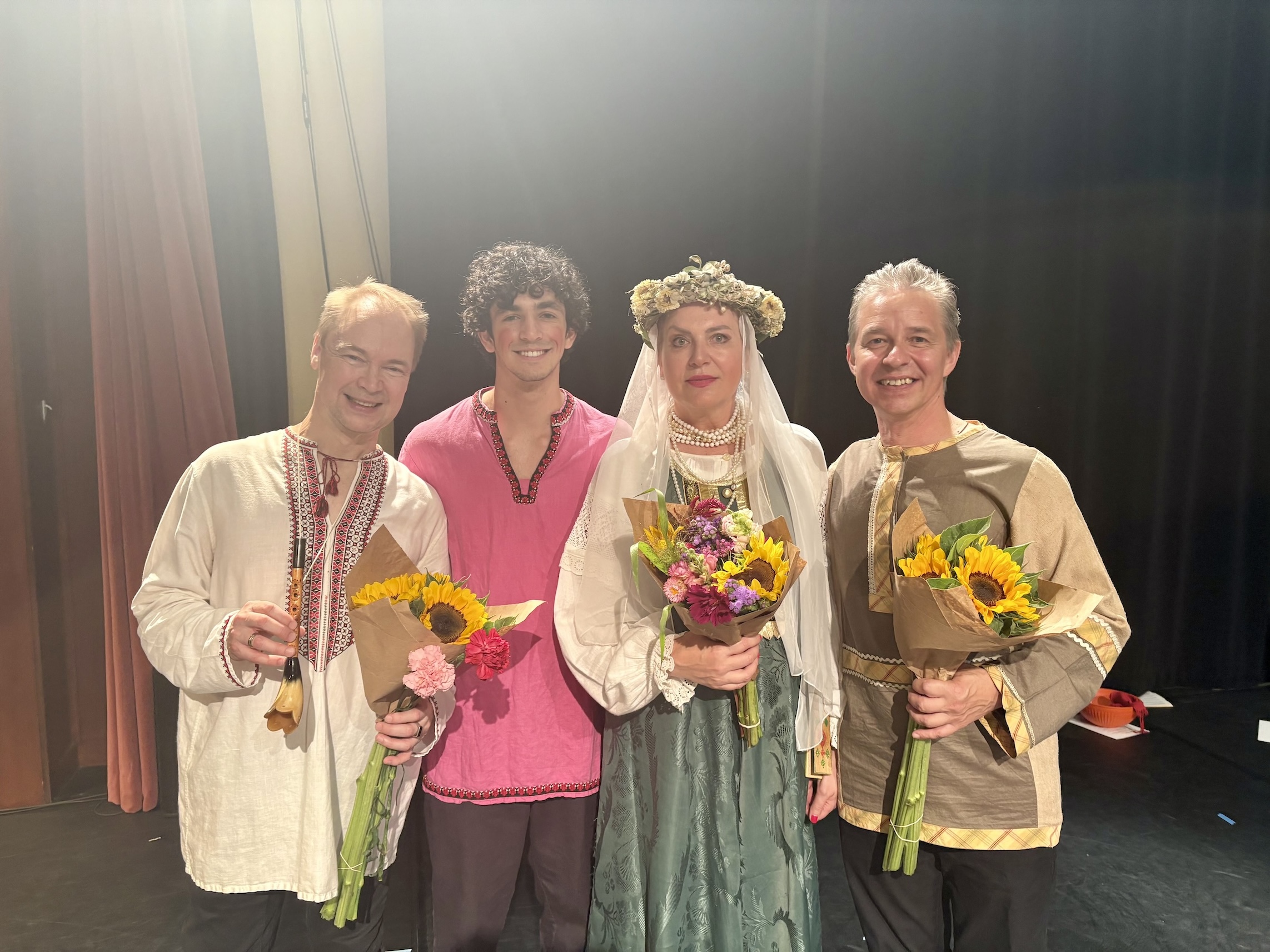 A group of professors and students at the School of Russian smile after a theatre performance.