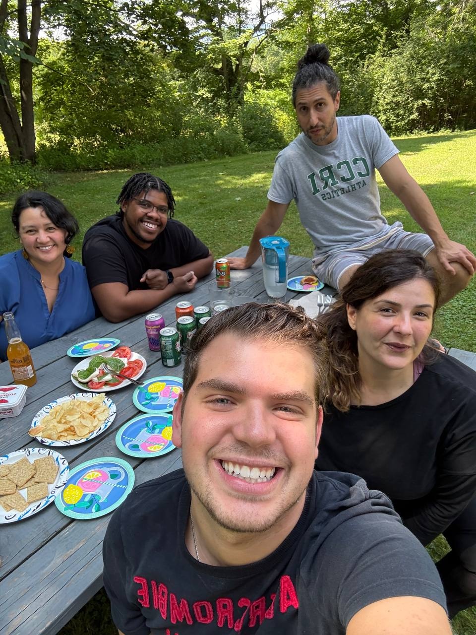 Friends eat at a picnic table. 