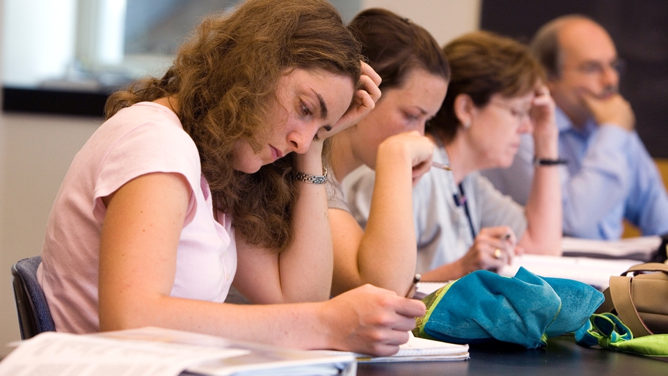 Four Italian language students in lecture hall, studying