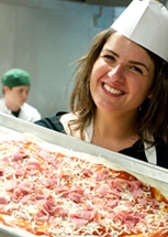 Student holding handmade pizza.