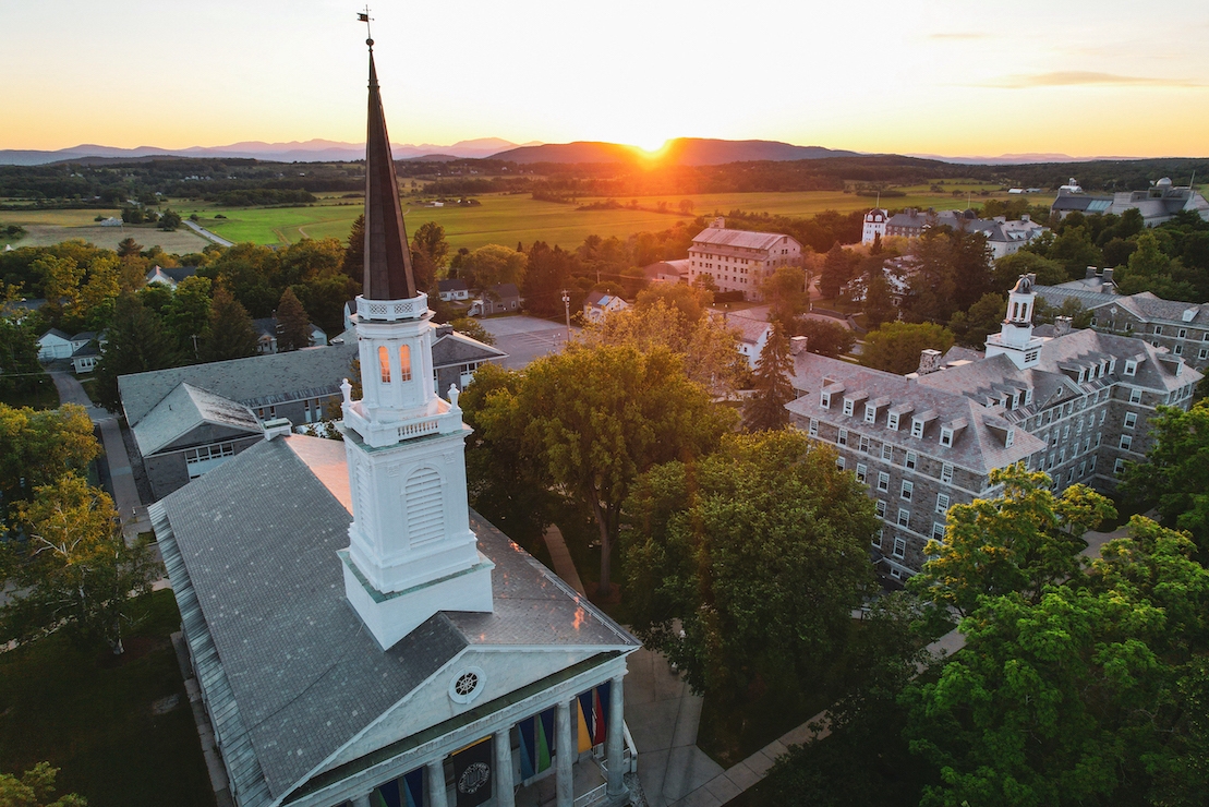 A view of the Middlebury College Chapel at sunset, the mountains in the distance.