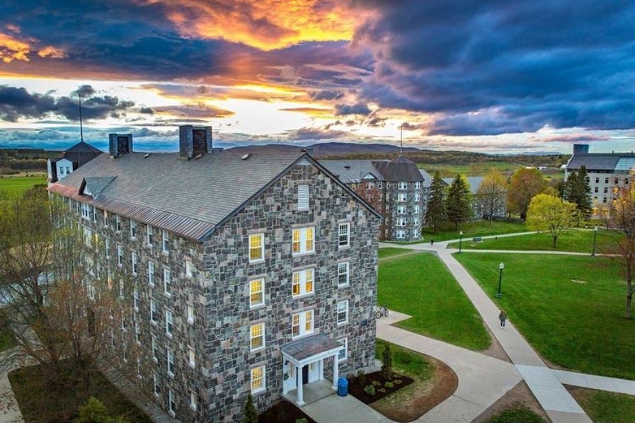 A college dorm made of gray stone during a summer sunset.