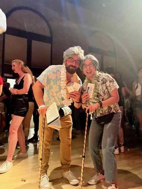 A couple dressed up as elderly folks holds up their costume contest prize. 