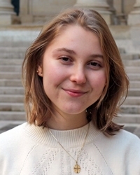 A woman in a white sweater smiles at the camera.