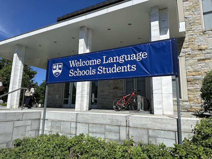 A blue sign reading "Welcome Language Schools Students"