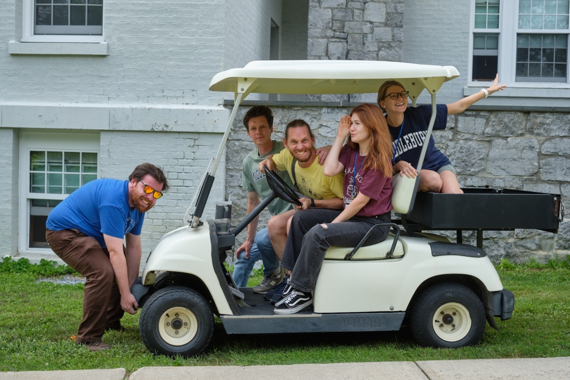 School of Russian bilingual assistants pose in a golf cart.