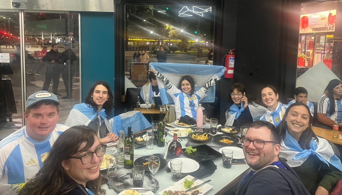 Students with Argentine flags celebrate at a restaurant.