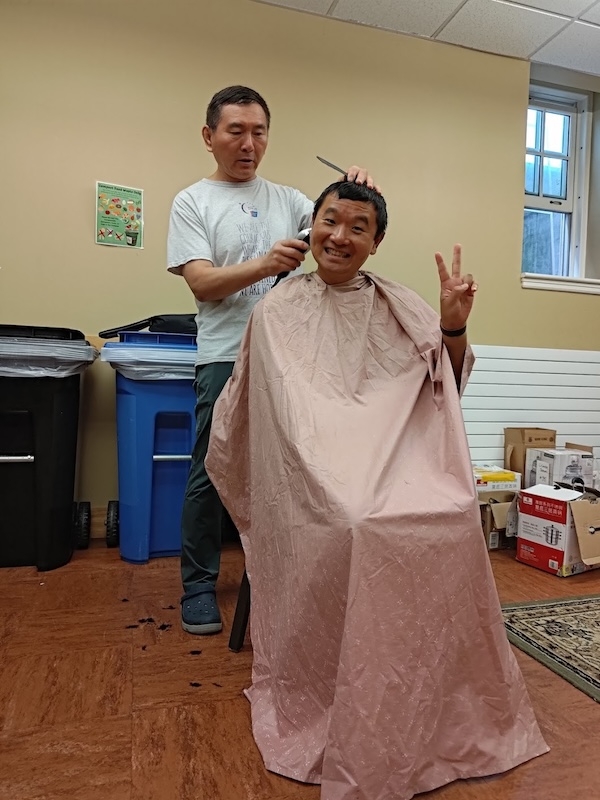 A man cuts another man's hair. 