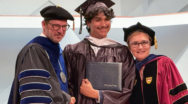 Picture of the president and a student at commencement.