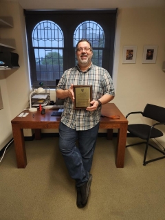 A man poses with his award. 