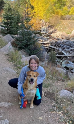 A woman and her dog smile at the camera. 