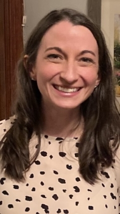 A woman in a polka dot shirt smiles at the camera. 