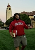 A man in a Stanford sweatshirt gives a thumbs up.