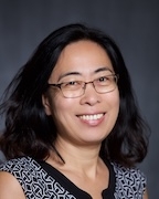 a woman in a black and white shirt smiles at the camera. 