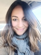 A woman in a scarf smiles at the camera. 